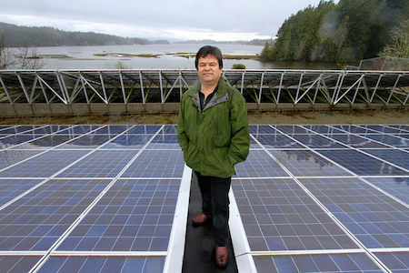 T'Sou-ke Chief Gordon Planes amongst a sea of solar modules on the canoe shed on Vancouver Island