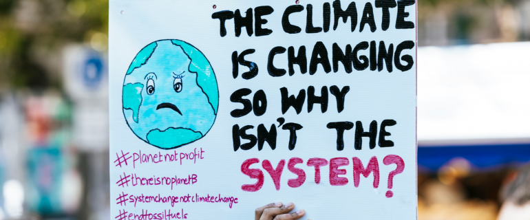 Climate poster reads 'The climate is changing so why isn't the system?'